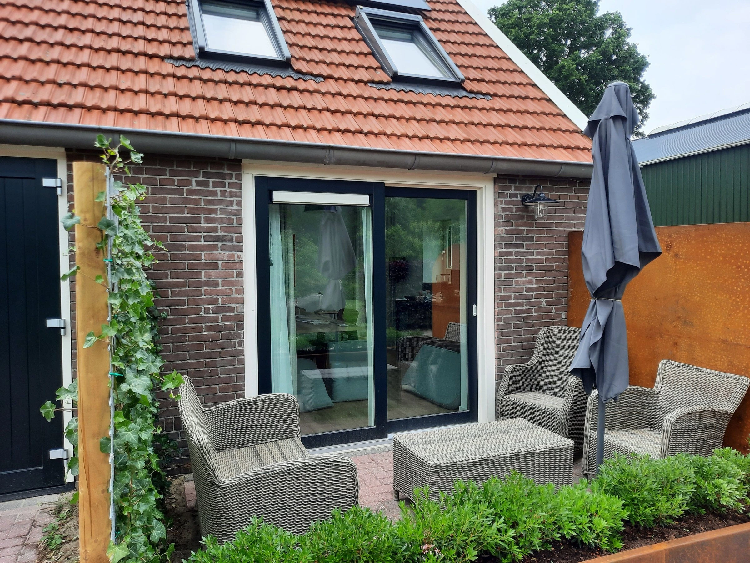 Eigen terras met loungestoelen voor de tuindeuren